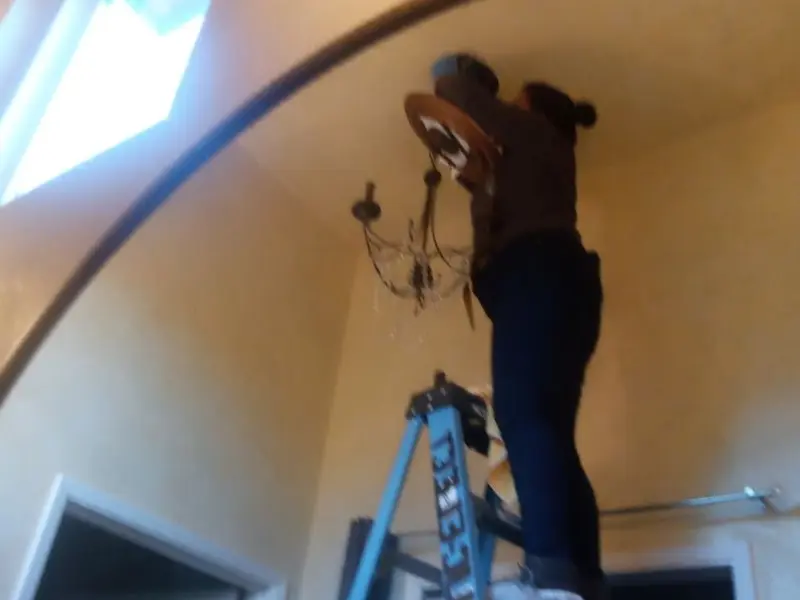 Electrician installing a chandelier in a Yorba Linda residence